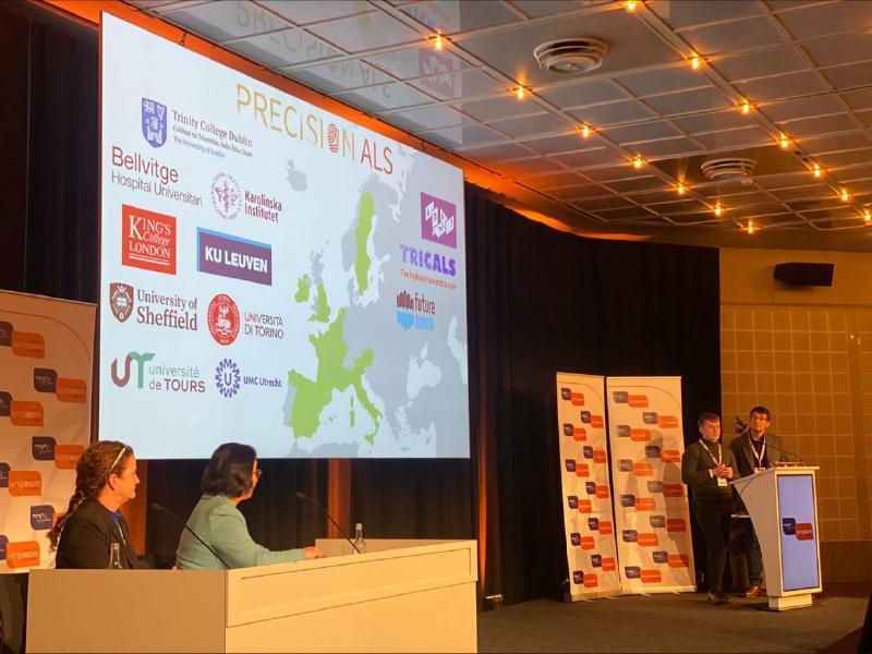 Alejandro Caravaca Puchades and Harry McDonough at the lectern during their platform communication at the 34th International Symposium on ALS/MND, with the PRECISION ALS consortium slide behind them